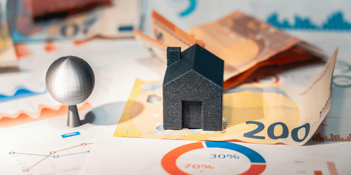 A model house and sphere on euro banknotes and financial charts.