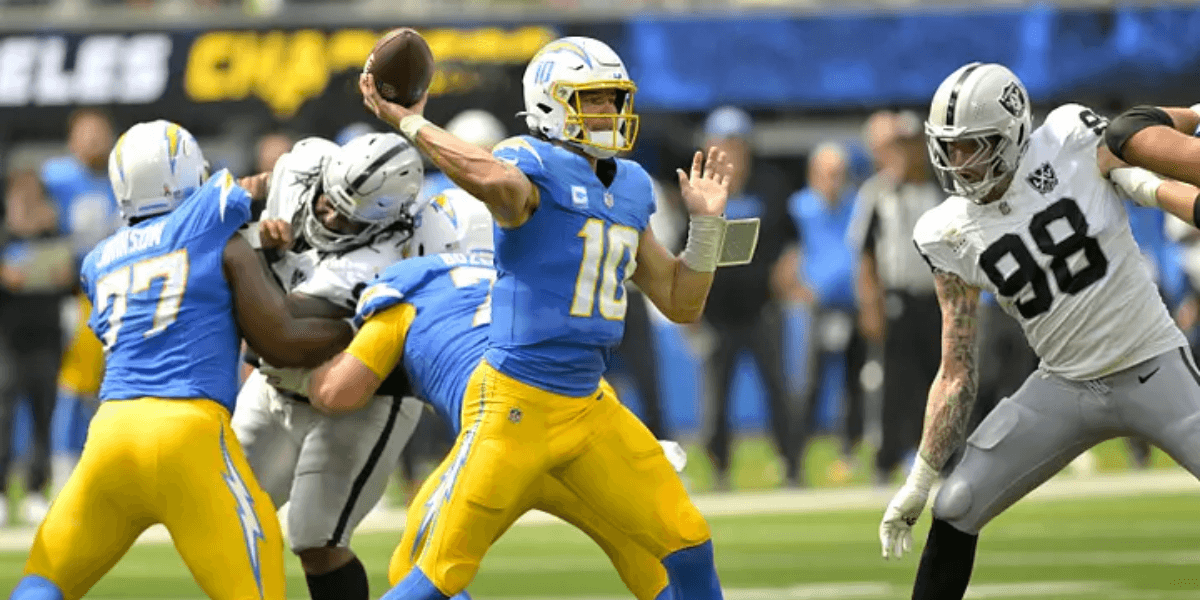 Quarterback throws a pass while defenders rush during an NFL game.