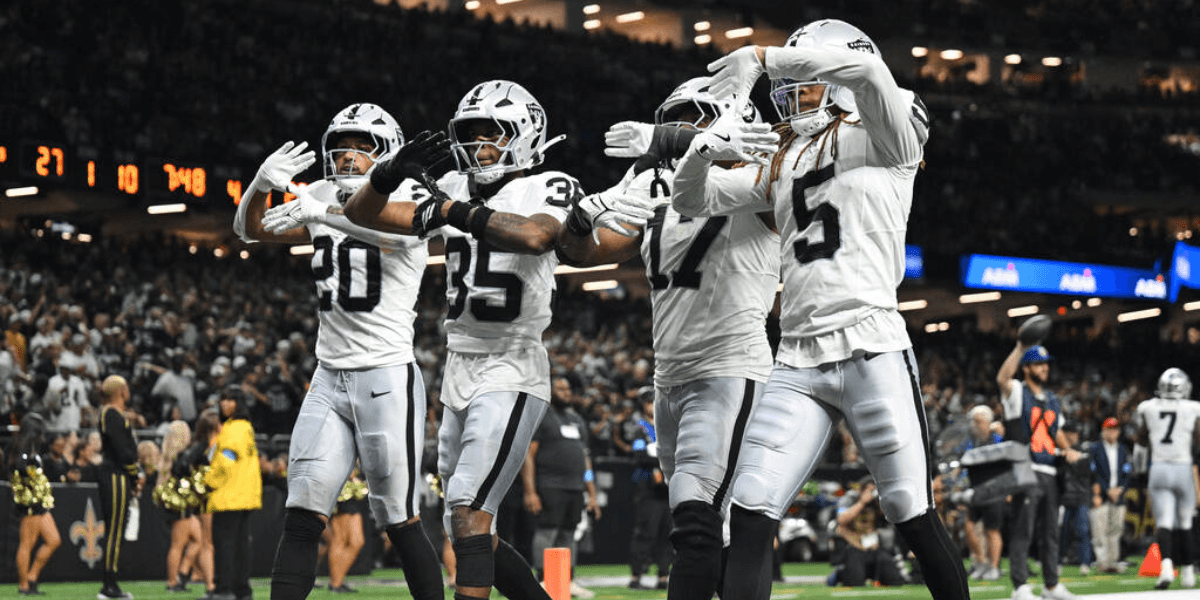 A group of football players celebrating a play in black and white uniforms