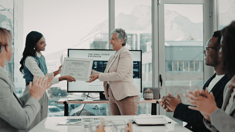 Employee receiving a workplace award certificate during an office recognition ceremony.