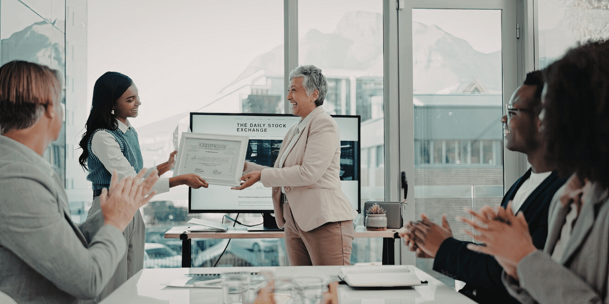 Employee receiving a workplace award certificate during an office recognition ceremony.