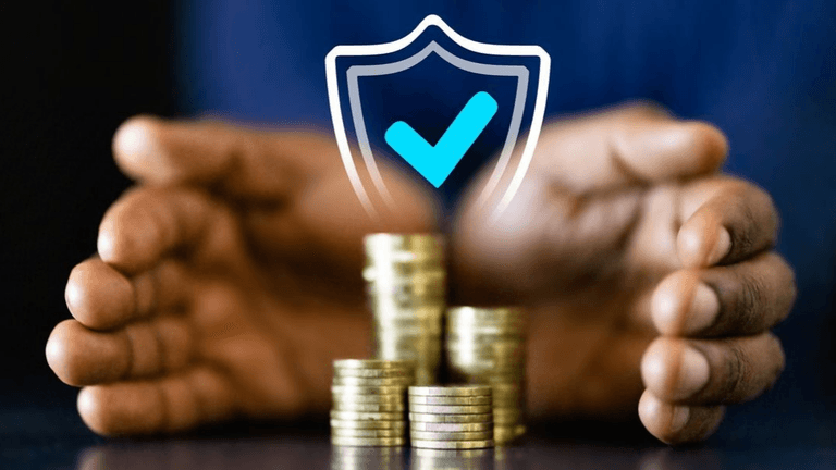 Hands protecting a stack of coins with a shield and checkmark graphic above