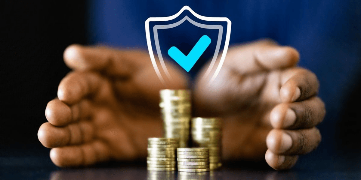 Hands protecting a stack of coins with a shield and checkmark graphic above