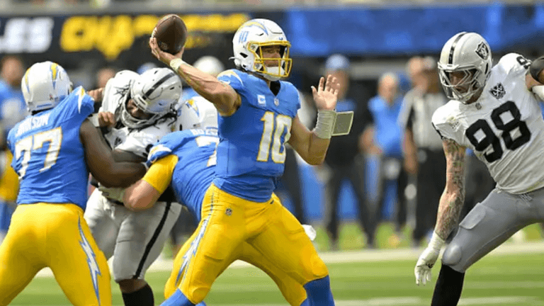 Quarterback throws a pass while defenders rush during an NFL game.