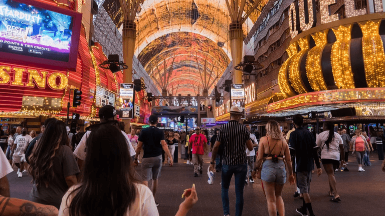 Crowd walking under bright lit canopies of Fremont Street in Las Vegas