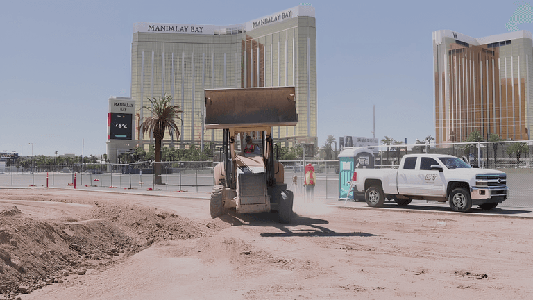 Construction work in progress with a bulldozer and Mandalay Bay in the background