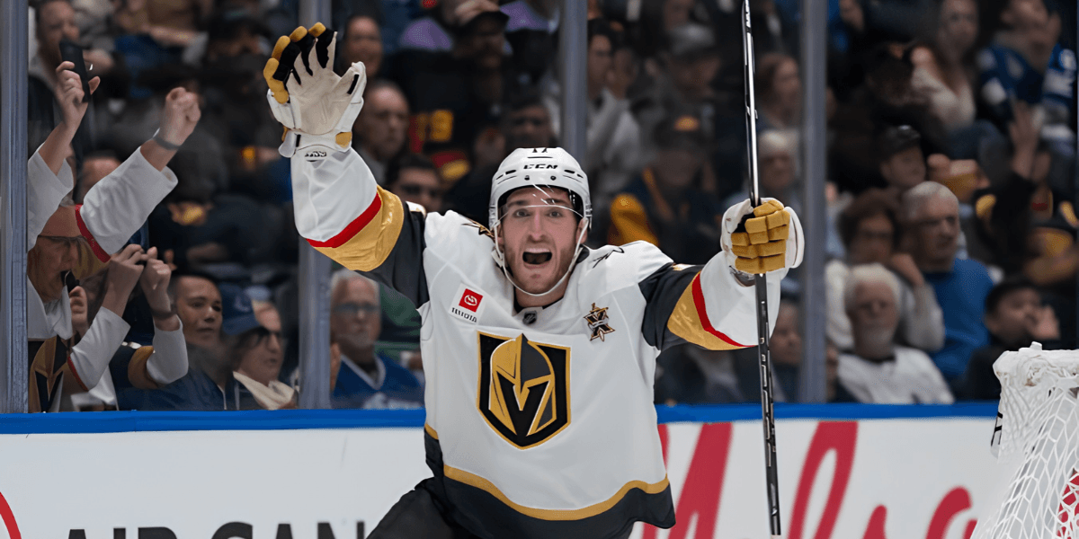 An excited hockey player celebrates a goal during a game in a crowded arena