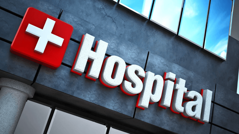 Sign of a hospital featuring a red cross and the word "Hospital" in bold letters