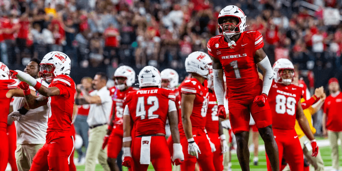Football team celebrating a successful play, wearing red uniforms in a stadium