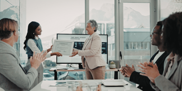 Employee receiving a workplace award certificate during an office recognition ceremony.