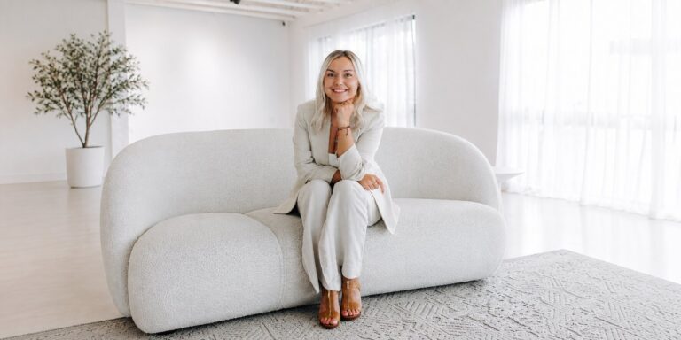 How Cobalt Media Freed Owners from Social Media Josey Lesmeister seated on a white sofa in a bright studio.