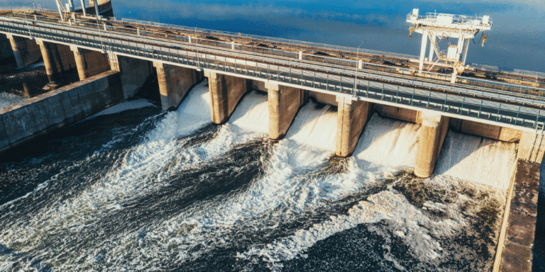Nevada Continues Water Conservation Efforts as Colorado River Planning Advances Water flows through open gates of a large dam structure with industrial equipment spanning the reservoir.